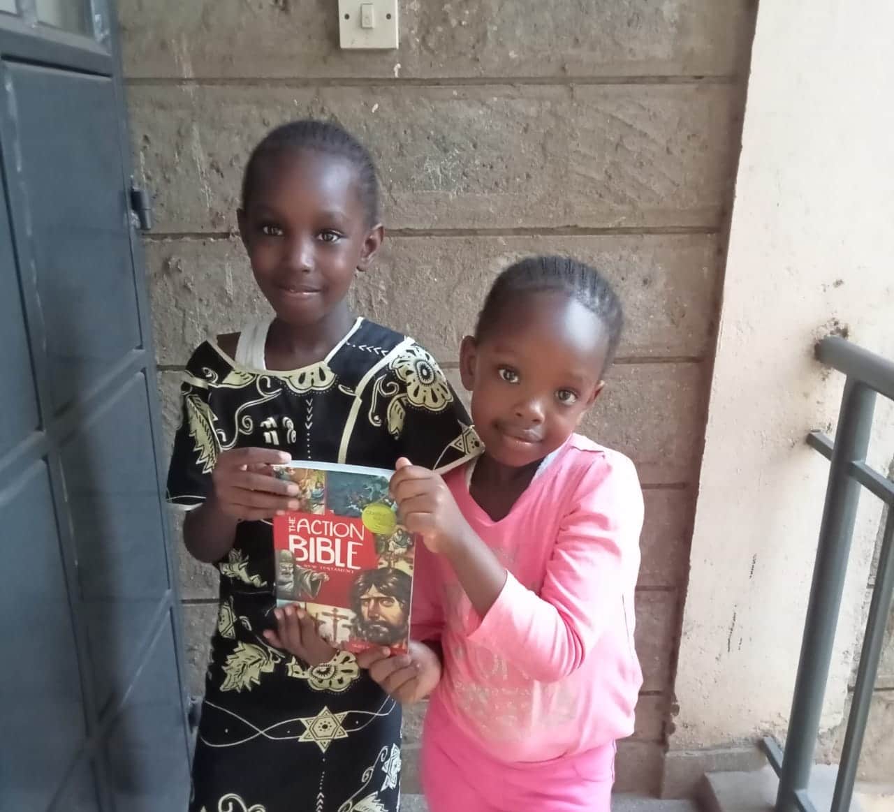 two children from Africa holding a donated Action Bible book